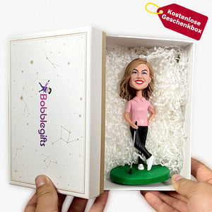 Glücklicher weiblicher Golfbobblehead im rosa Hemd